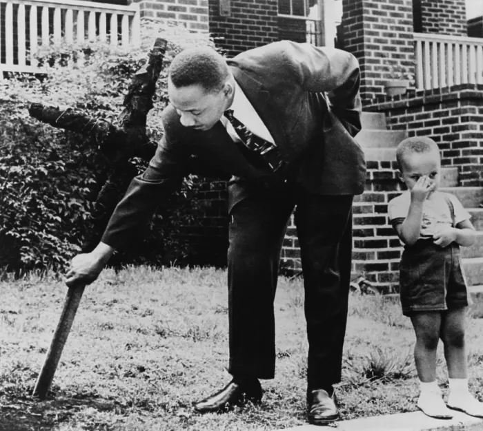 Framed Print : Martin Luther King, removes a KKK cross burned on lawn of his home, as his son Martin stands next to him, Atlanta, Georgia. April 27, 1960