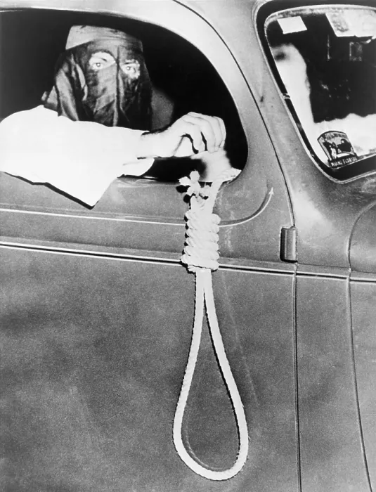 Framed Print : Masked Ku Klux Klan member, holds a noose outside a car window during a parade through an African American neighborhood of Miami on the night before a primary election in May 1939