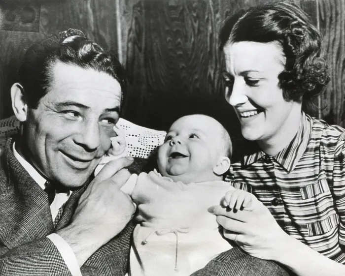Framed Print : Max Baer with his wife, Mary Ellen Sullivan, and Max Baer Jr. on March 19, 1938. The baby feels Baer's swollen eye, a souvenir of his recent victorious bout with Tommy Farr