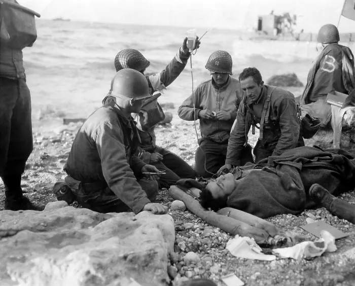 Framed Print : Medics administer a plasma transfusion to a wounded soldier on Omaha Beach on D-day. He is a survivor of a landing craft sunk in the Allied invasion of Normandy