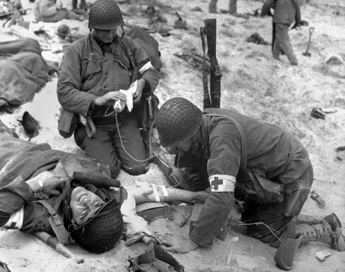 Framed Print : Medics treat a wounded U.S. soldier on D-Day. During the Normandy landings in Nazi occupied France, June 6, 1944, World War 2. (BSLOC_2014_2_37)