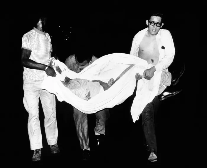 Framed Print : Three men carry body of a youth who died after apparently falling from a rooftop during third night of civil disorder in Spanish Harlem on July 25, 1967