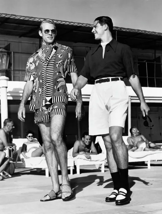 Framed Print : Men wearing the latest beach fashions. On the left, a colorful Mexican design; on the right, longer shorts and an open collar shirt. November, 1947
