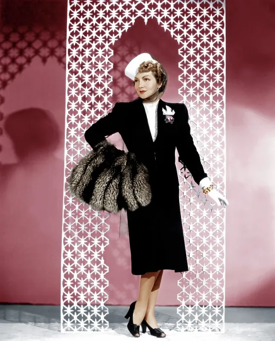 Framed Print : MIDNIGHT, Claudette Colbert, in a black wool suit by Irene, with a crystal-beaded blouse and silver fox muff, 1939