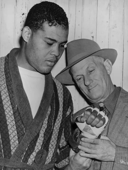 Framed Print : Mike Jacobs inspects Joe Louis fist before the heavy weight champion would defend his title against Lou Nova on Sept. 29, 1941