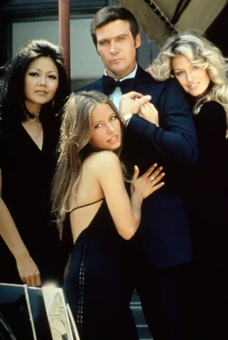 Framed Print : SIX MILLION DOLLAR MAN: WINE WOMEN AND WAR, Lee Majors (center), Farrah Fawcett (right), (publicity photo for tv movie / pilot), 1973