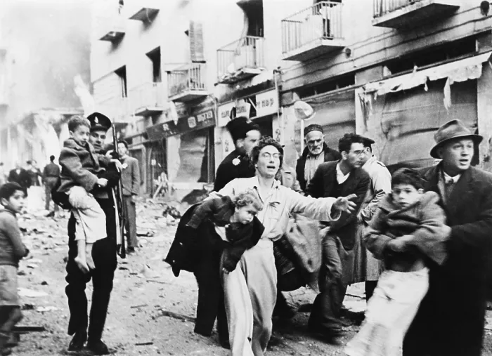 Framed Print : Mother and her family fleeing from square block of buildings in the Jewish district of Jerusalem, which were blasted to rubble in February 1948. Photo by Lasar Dunner