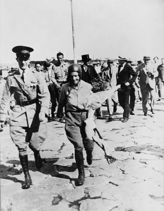 Framed Print : Mrs. Anne Morrow Lindbergh escorted by Japanese officer, with her husband, Charles (in background) after their arrival at Nemuro, Japan
