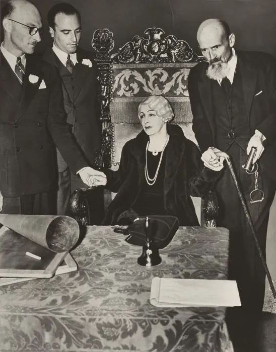 Framed Print : Mrs. Bess Houdini, widow of the great magician, sitting in a chair with her business manager, Edward Saint (to her left holding handcuffs), and others, during a seance Framed Print : Mrs. Bess Houdini, widow of the great magician, sitting in a chair with her business manager, Edward Saint (to her left holding handcuffs), and others, during a seance