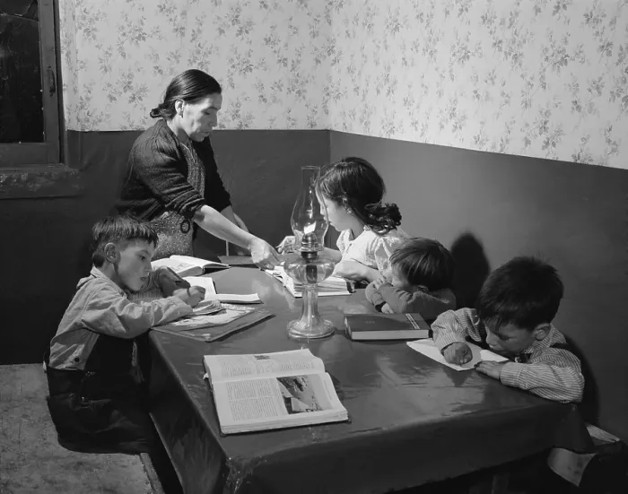 Framed Print : Mrs. Maclovia Lopez, a bilingual Spanish-American mother, supervises her children's homework in their Trampas, New Mexico home. 1943 photograph by John Collier