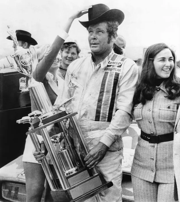Framed Print : NASCAR racecar driver Buddy Baker after winning the Texas 500, Nov. 12, 1973. His average speed was 147.059 miles per hour. With him in victory circle is his wife, Coline