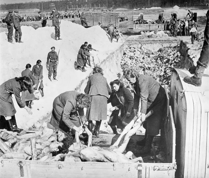 Framed Print : Nazi SS women guards remove victims bodies from a truck during burial at Belsen Concentration Camp. British solders guard and oversee the work