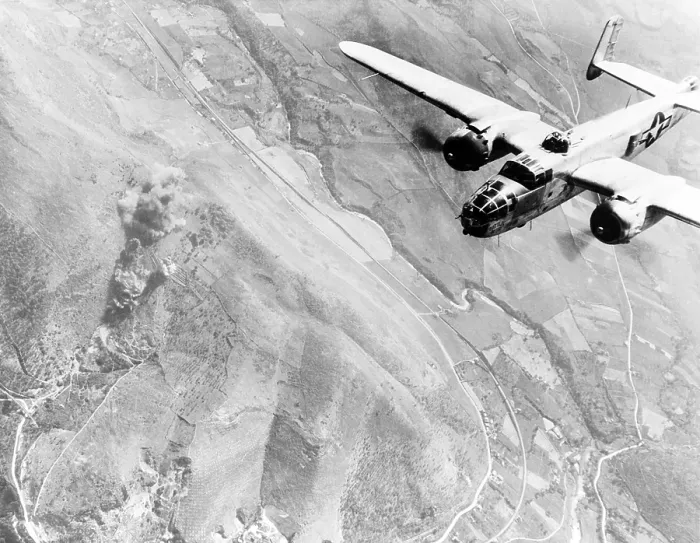 Framed Print : A Nazi supply dump goes up in smoke. A U.S. B-25 medium bomber roars over Tivoli, Nazi supply center ten miles east of Rome