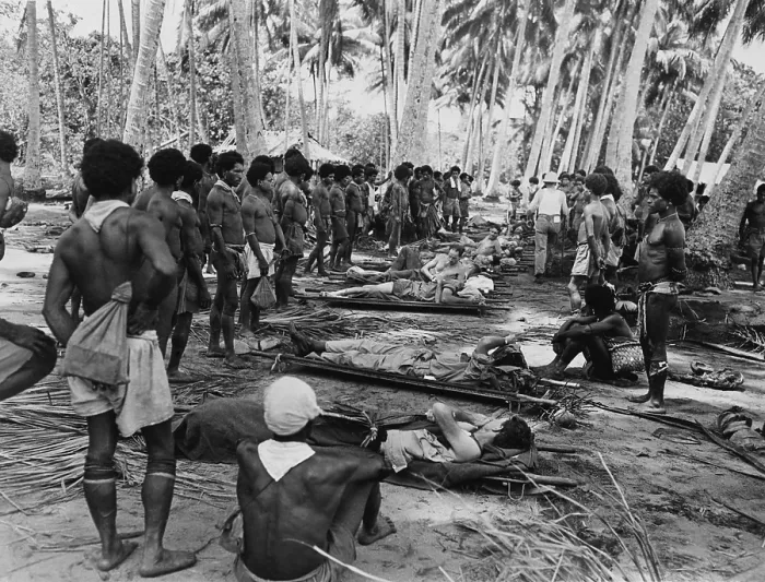 Framed Print : New Guinean native stretcher bearers pause in their transport of American wounded