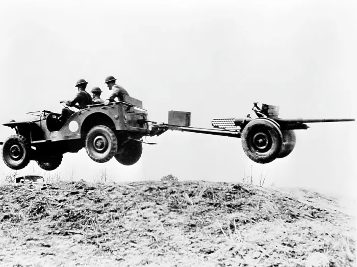 Framed Print : The new jeep in mid-air as it pulls a small artillery piece ca. 1941
