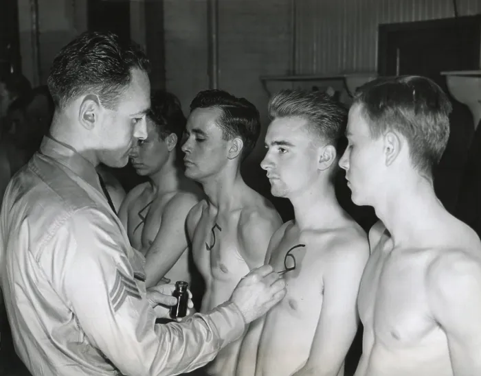 Framed Print : New recruits to the U.S. Army starting their physical exam. The sergeant paints an identification number on the chest of each man to be used throughout the physical examination