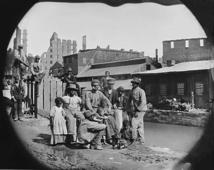 Framed Print : A newly freed African American group of men and a few children posing by a canal against the ruins of Richmond, Virginia