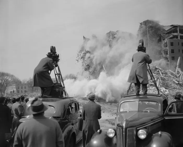 Framed Print : News photographers filming a building demolition in Washington, D.C. ca. 1940. They are standing on the top of automobiles to get a better angle of the explosion scene
