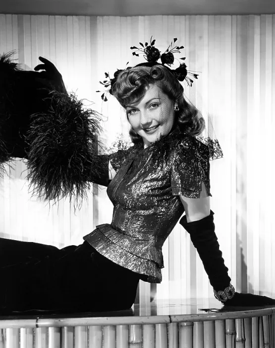 Framed Print : THE NIGHT BEFORE THE DIVORCE, Lynn Bari, in a cocktail outfit of a silver-lame blouse over a black velvet skirt, with suede gloves and an ostrich-feather muff, 1942