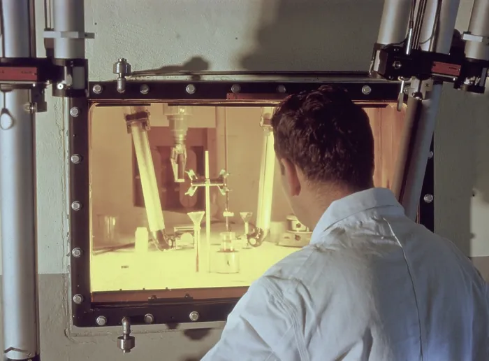 Framed Print : Nuclear engineer is protected from radiation by a fifty-two inch thick, oil-filled glass window as he examines irradiated materials Framed Print : Nuclear engineer is protected from radiation by a fifty-two inch thick, oil-filled glass window as he examines irradiated materials