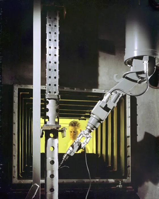 Framed Print : A nuclear engineer is protected from radiation by a fifty-two inch thick oil-filled, glass window as he operates a robotic arm