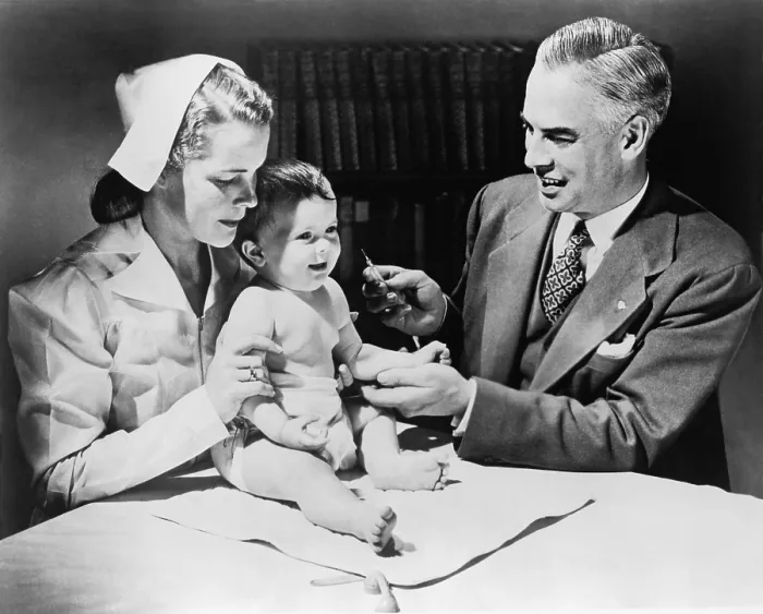 Framed Print : Nurse holding an infant as a doctor prepares to immunize the child against influenza. 1958