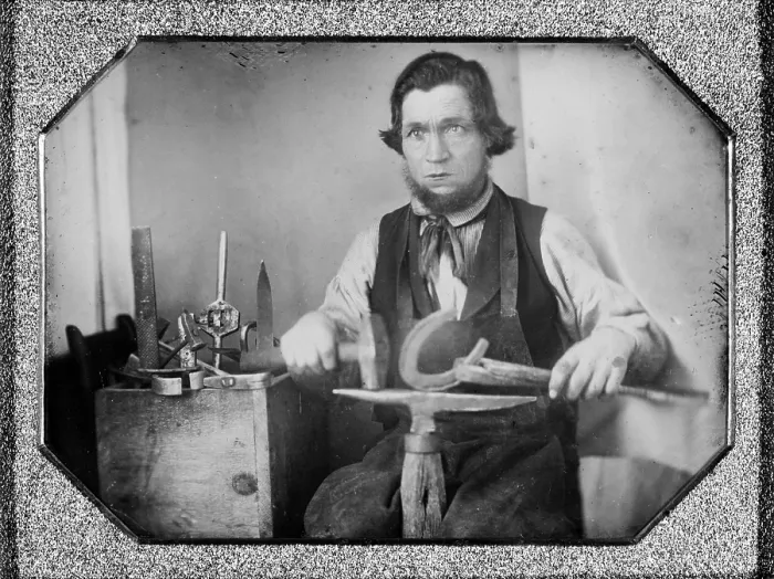 Framed Print : Occupational portrait of a blacksmith, working on a horseshoe at an anvil, other tools to his side. quarter plate daguerreotype, 1840-1860 Framed Print : Occupational portrait of a blacksmith, working on a horseshoe at an anvil, other tools to his side. quarter plate daguerreotype, 1840-1860