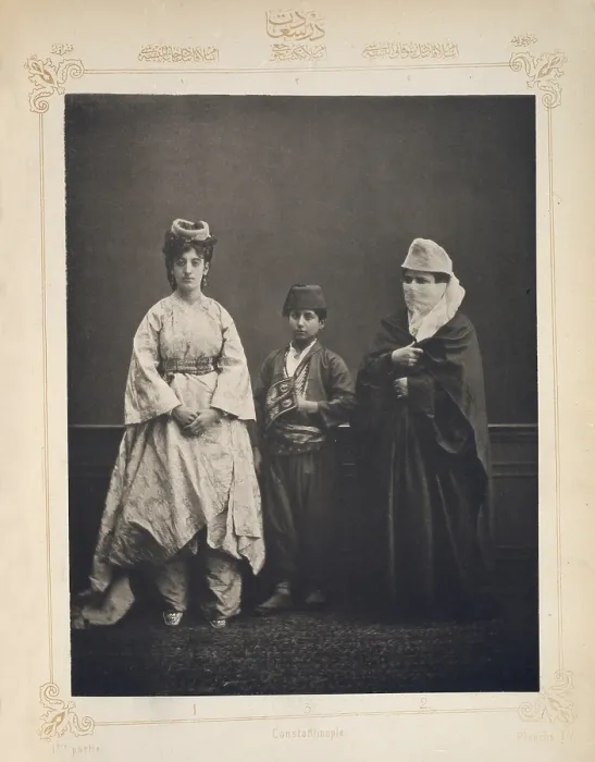 Framed Print : The Ottoman Empire, studio portrait of models wearing traditional clothing from Istanbul, Turkish woman of Constantinople wearing indoor dress, Turkish schoolboy