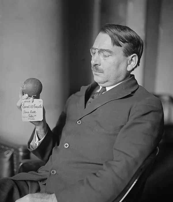 Framed Print : A US Patent Office official holds the patent model of an early baseball, patented in 1883. photo ca 1925