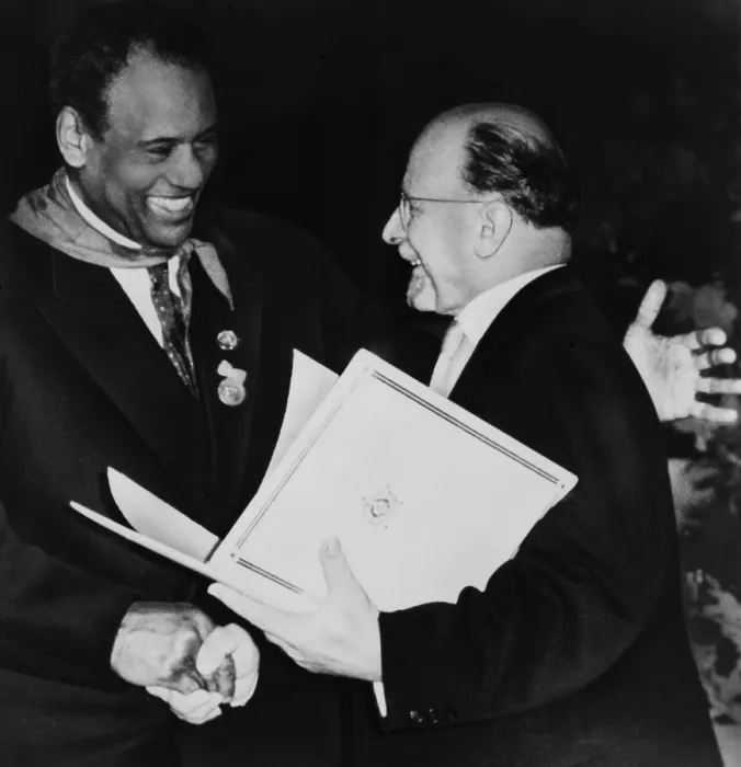 Framed Print : Paul Robeson (1898-1976), dances a freedom dance with an amateur African cultural group during his visit communist East Germany in 1960 Framed Print : Paul Robeson (1898-1976), dances a freedom dance with an amateur African cultural group during his visit communist East Germany in 1960