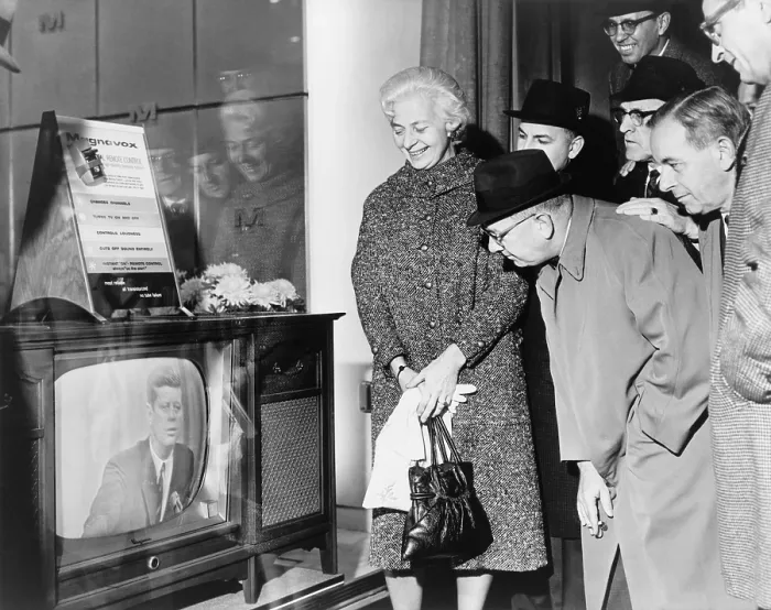 Framed Print : People gather around a television outside a store window on a New York street as President John F. Kennedy speaks during a press conference on November 21, 1962