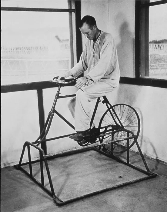 Framed Print : Physical therapy patient using stationary bicycle. Ca. 1950