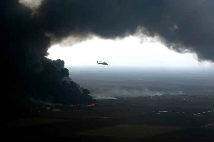 Framed Print : A plume of smoke surrounds a U.S. Army Black Hawk helicopter observing an oil pipeline fire outside Forward Operating Base McHenry Iraq on Dec. 27 2005. (BSLOC_2011_3_12)