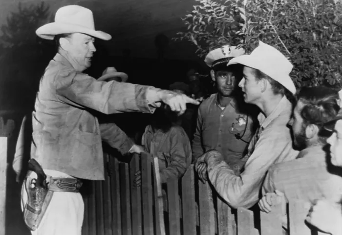 Framed Print : Police chief instructs officers and young men on the other side of a fence, at a polygamist settlement in Short Creek, Arizona