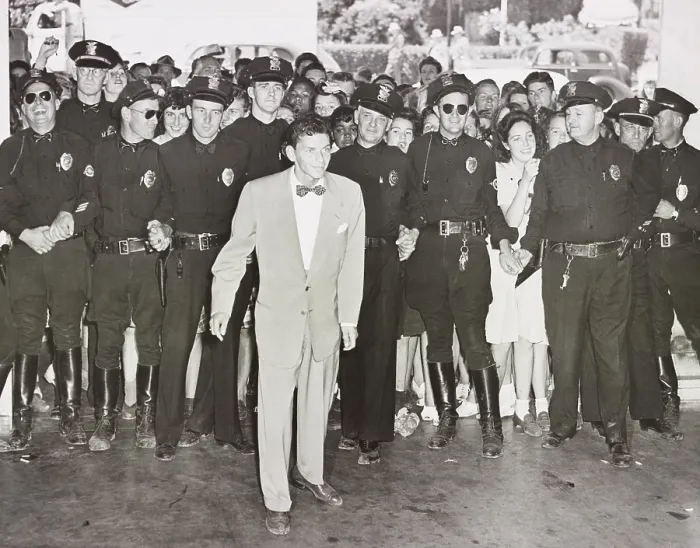 Framed Print : A police line protects Frank Sinatra from a crowd of young fans on his arrival at the Pasadena, California train station, Aug. 11, 1943 (BSLOC_2020_2_1)