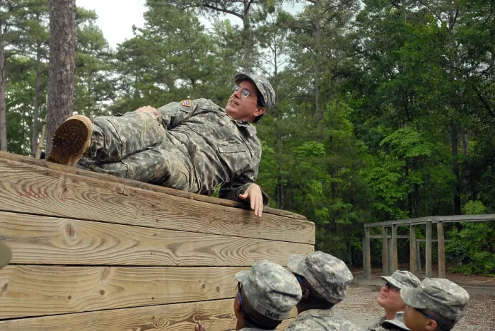 Framed Print : Political humorist Stephen Colbert tackles Basic Training. Army Private for a day Colbert rests atop an obstacle course wall rather than aiding his fellow Soldiers. June 2009