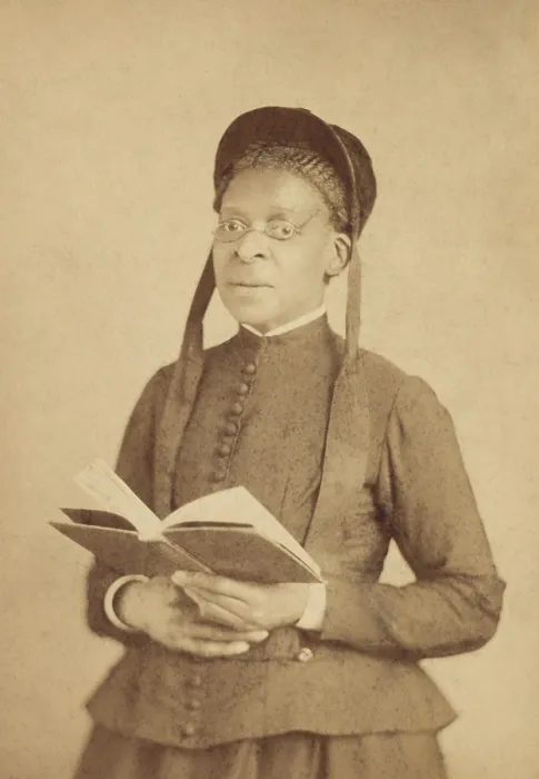 Framed Print : Portrait of an African American woman, wearing glasses, and posed with book, c. 1880-1900