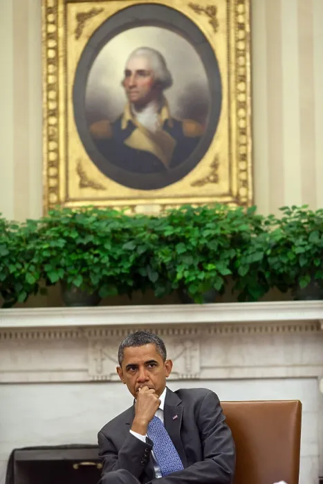 Framed Print : President Barack Obama listens to advisors in the Oval Office. Aug. 18, 2011. Above him is the Porthole Portrait of George Washington (1795) by Rembrandt Peale. (BSLOC_2015_3_7)