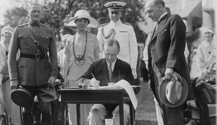 Framed Print : President Calvin Coolidge (1872-33) signing appropriation bills for the Veterans Bureau on the south lawn during the garden party for wounded veterans in 1924. Mrs