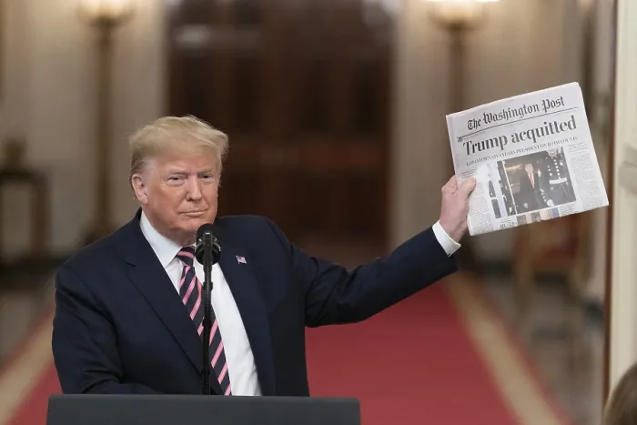 Framed Print : President Donald Trump holds up a Washington Post newspaper with the headline ACQUITTED at the East Room of the White House, Feb. 6, 2020