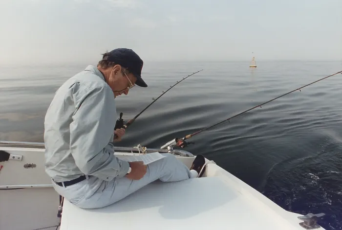 Framed Print : President George H.W. Bush reading a long memo as he fishes at his summer home in Kennebunkport Maine. Ca. 1990
