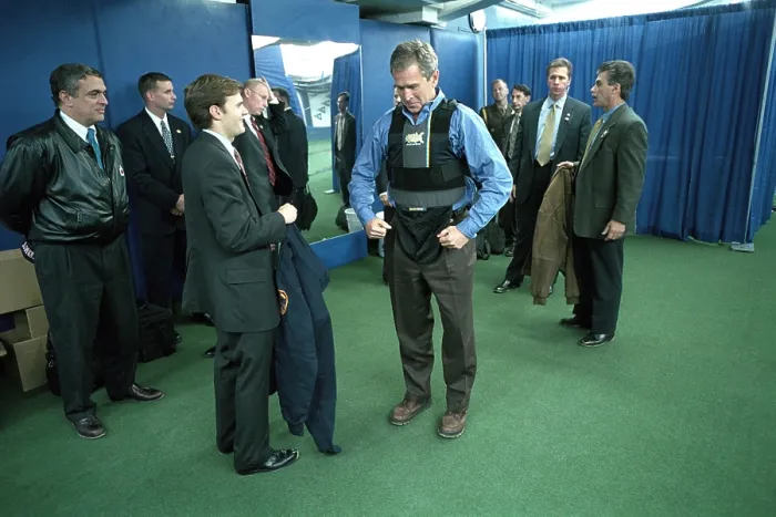 Framed Print : President George W. Bush puts on a vest before the first pitch in Game 3 of the World Series. At left is CIA Director, George Tenet. (BSLOC_2015_2_180)