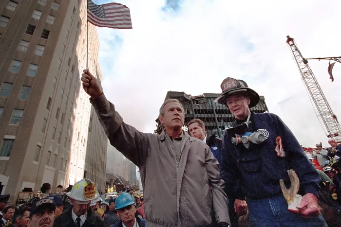 Framed Print : President George W. Bush waves an American flag after addressing recovery workers in NYC. Sept. 14, 2001. With Bush is retired New York City firefighter Bob Beckwith Framed Print : President George W. Bush waves an American flag after addressing recovery workers in NYC. Sept. 14, 2001. With Bush is retired New York City firefighter Bob Beckwith