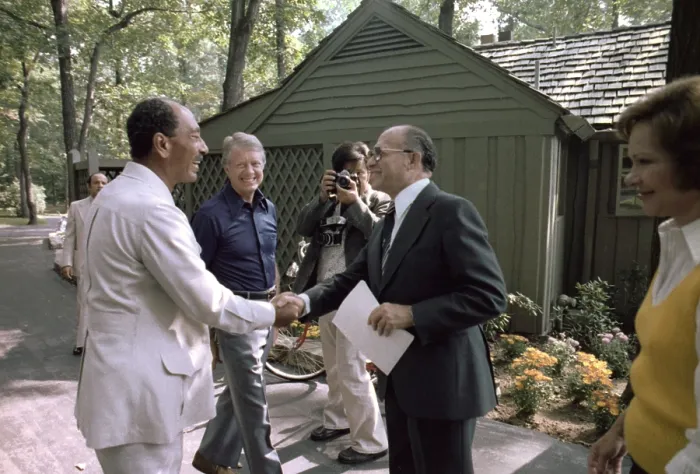 Framed Print : President Jimmy Carter watches Egyptian president Anwar Sadat (L) shake hands with Israeli prime minister Menachem Begin (R). First Lady Rosalynn Carter is at far right