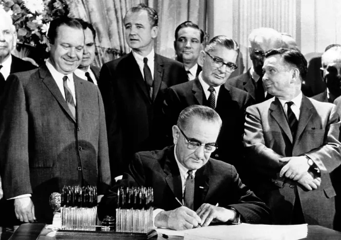 Framed Print : President Lyndon Johnson signs a $11.5 billion tax cut bill. Standing, L-R: Russell Long; Al Ullman; George Smathers; Pat Jennings; Wilbur Mills; John McCormack; Carl Albert. Feb
