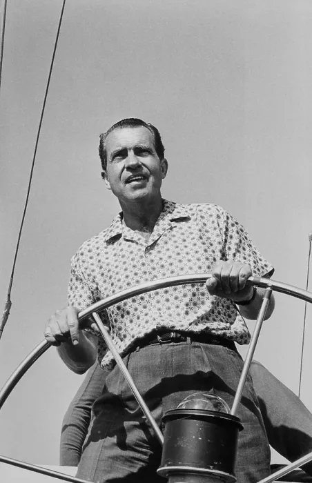 Framed Print : President Richard Nixon behind the wheel on of a boat. Ca. 1969-74