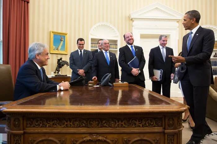 Framed Print : President Sebastian Pinera of Chile sits at the Obama's Resolute Desk in the Oval Office. The Chilean delegates share the good humor. June 4, 2013. (BSLOC_2015_3_151)