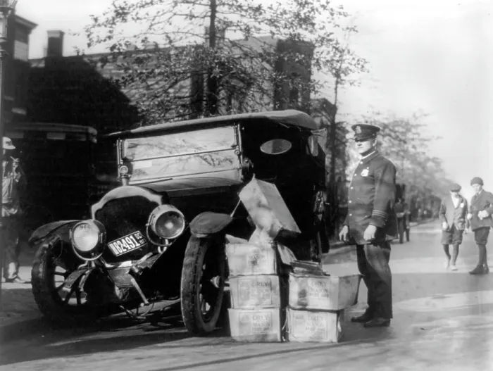 Framed Print : Prohibition, a policeman standing alongside a wrecked car and cases of moonshine, November 16, 1922