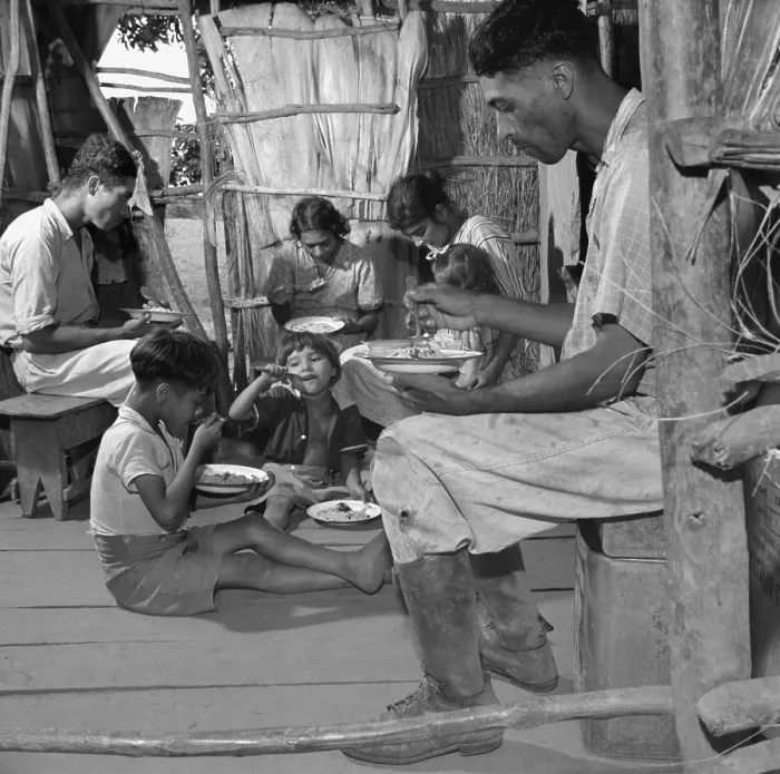 Framed Print : Puerto Rican family eating their main meal: rice, beans and a few pieces of codfish, Jan. 1938. The open tropical home interior is unfinished but clean. Photo by Edwin Rosskam