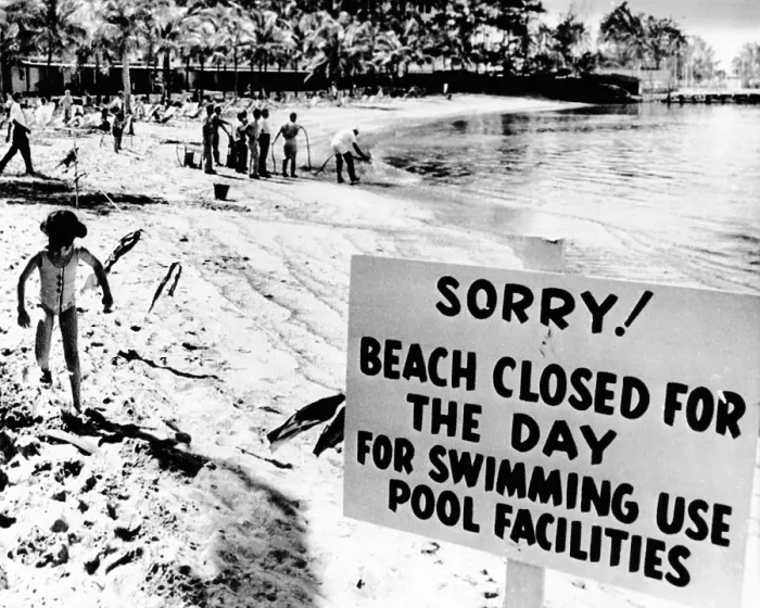 Framed Print : Puerto Rican Hilton Hotel beach closed by an oil spill. Workers in the background spray chemicals to clear the beach of crude oil leaking from a wrecked tanker offshore Framed Print : Puerto Rican Hilton Hotel beach closed by an oil spill. Workers in the background spray chemicals to clear the beach of crude oil leaking from a wrecked tanker offshore